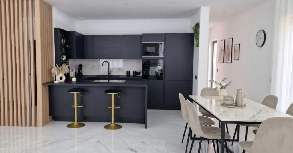 Visione d'insieme di un open space moderno con cucina a vista total black modello Venere e zona living luminosa