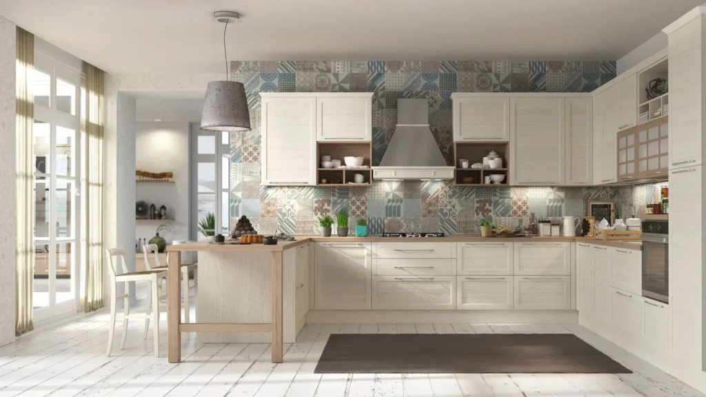 Cucina classica Glenda Old luminosa con penisola in legno, sgabelli bianchi, cappa in acciaio e paraschizzi a maiolica.