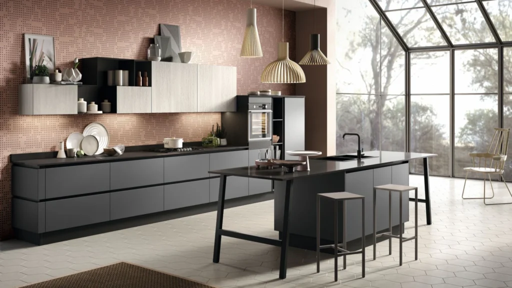Cucina con isola Ines Dark di BEHOME: basi grigio scuro, pensili chiari, tavolo integrato e due sgabelli.