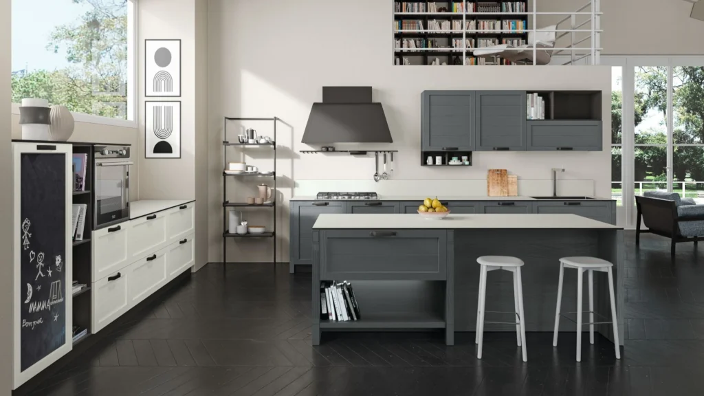 Ampia Cucina Moderna Glenda On con isola grigio antracite, sgabelli bianchi, cappa scura e colonna a lavagna.