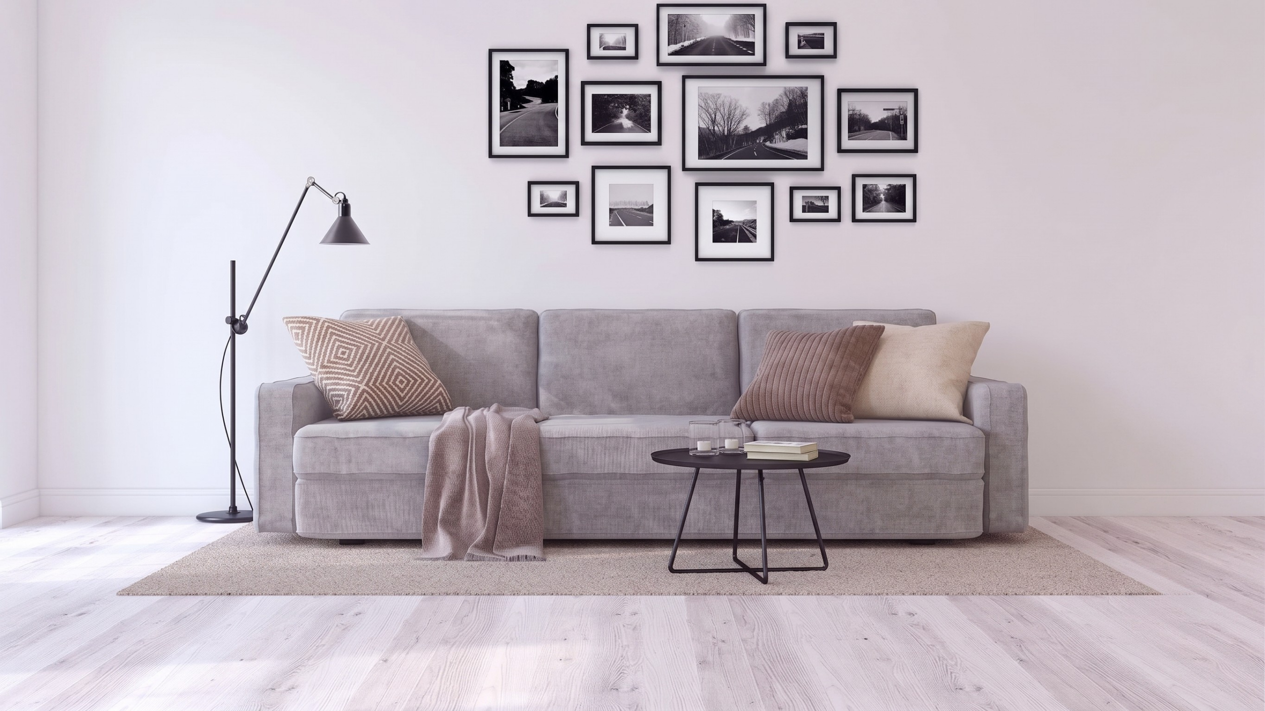 Divano a tre posti Siattle In di BEHOME grigio chiaro con cuscini decorativi e plaid.