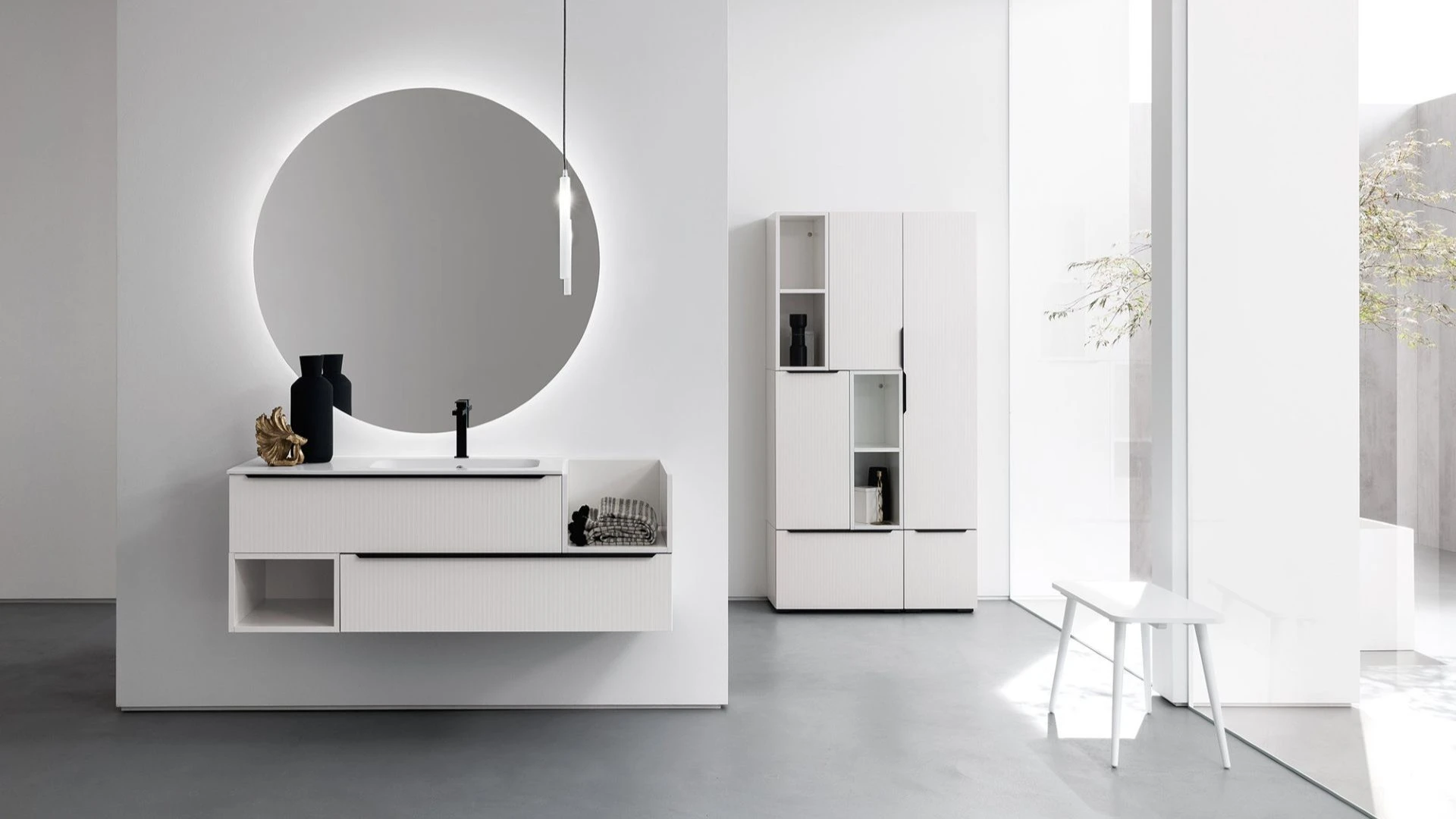 Mobile bagno sospeso Bianca di BEHOME bianco con specchio rotondo in bagno moderno.