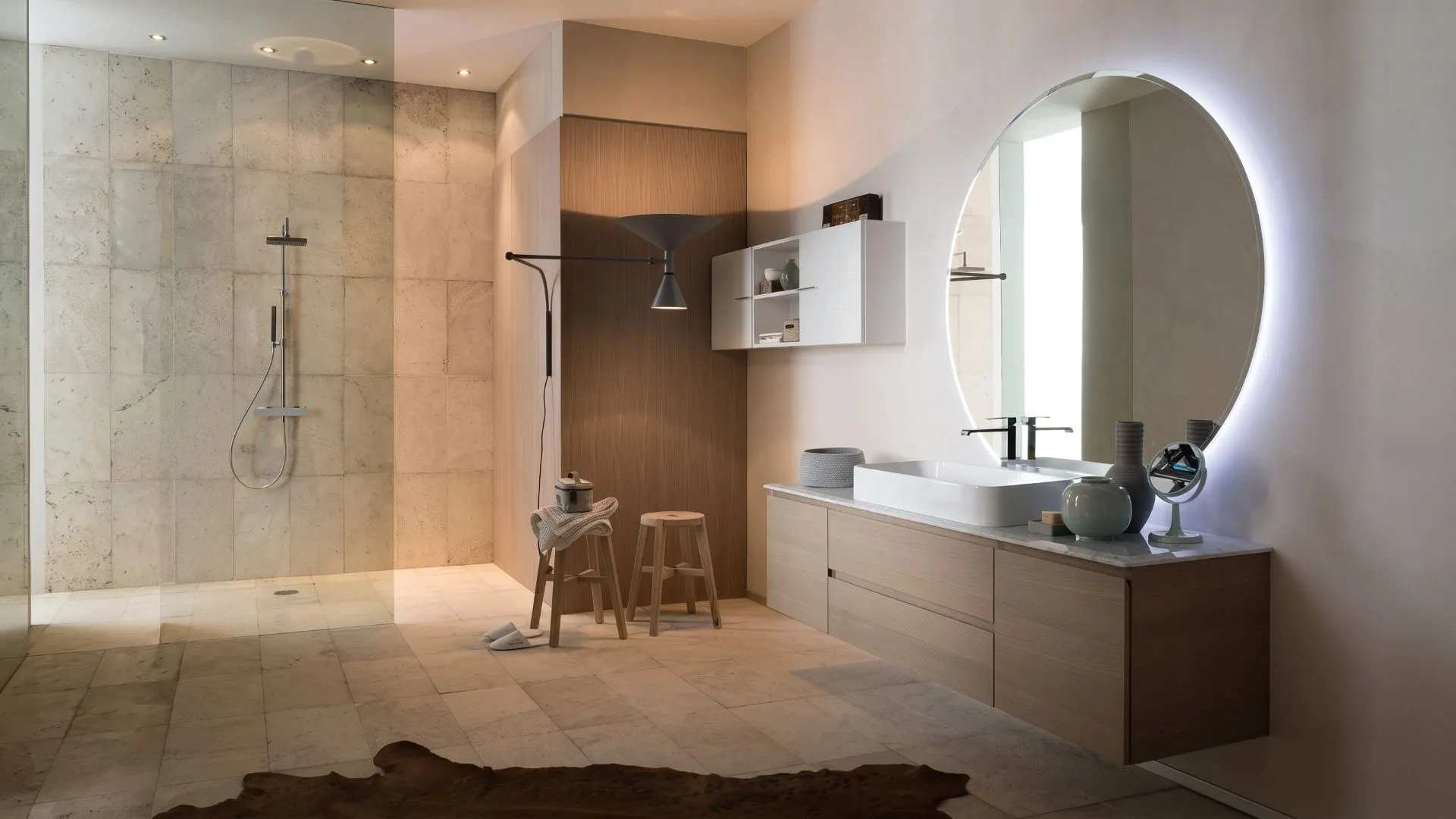 Mobile bagno sospeso Damiano di BEHOME in legno chiaro con lavabo bianco e grande specchio rotondo.