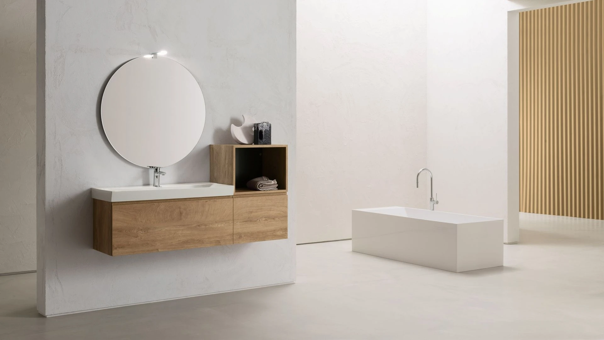 Mobile da bagno sospeso David di BEHOME in legno chiaro con specchio rotondo e vasca.