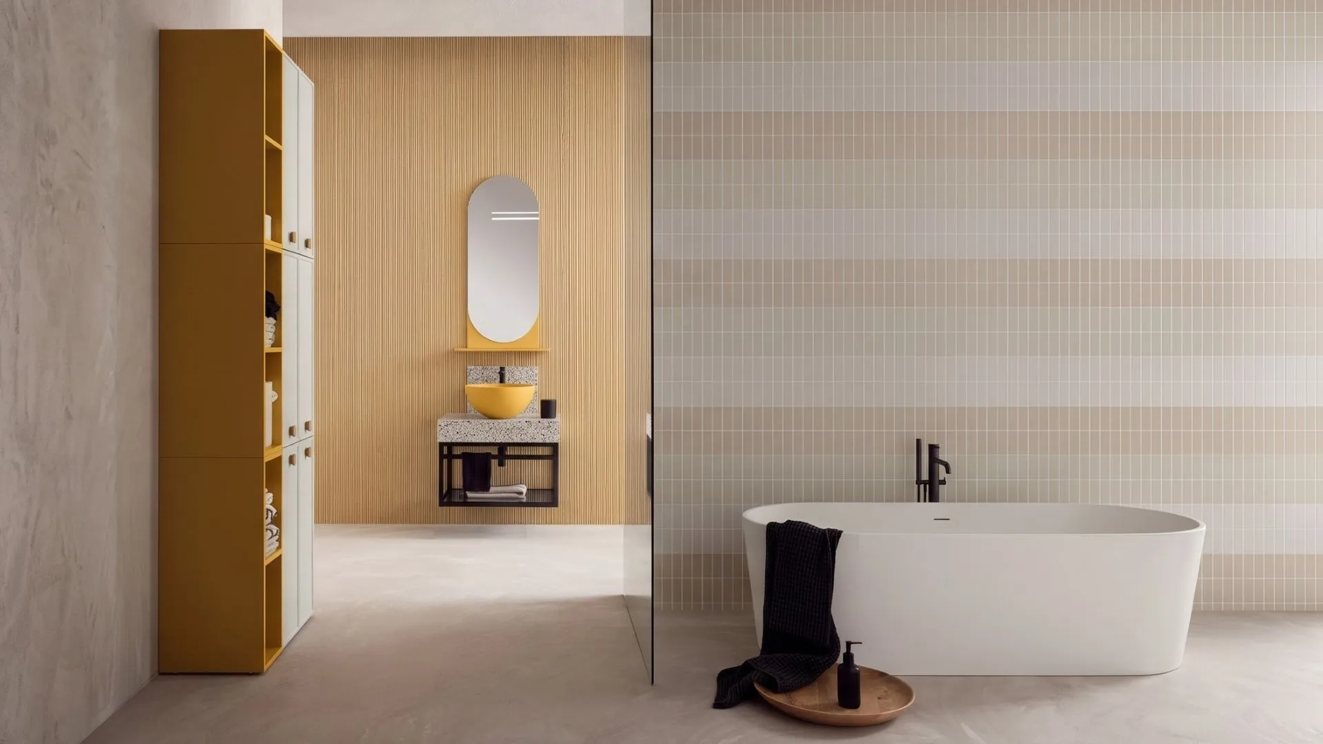 Mobile bagno Eufemia di BEHOME con colonna gialla, lavabo su top in graniglia e vasca.