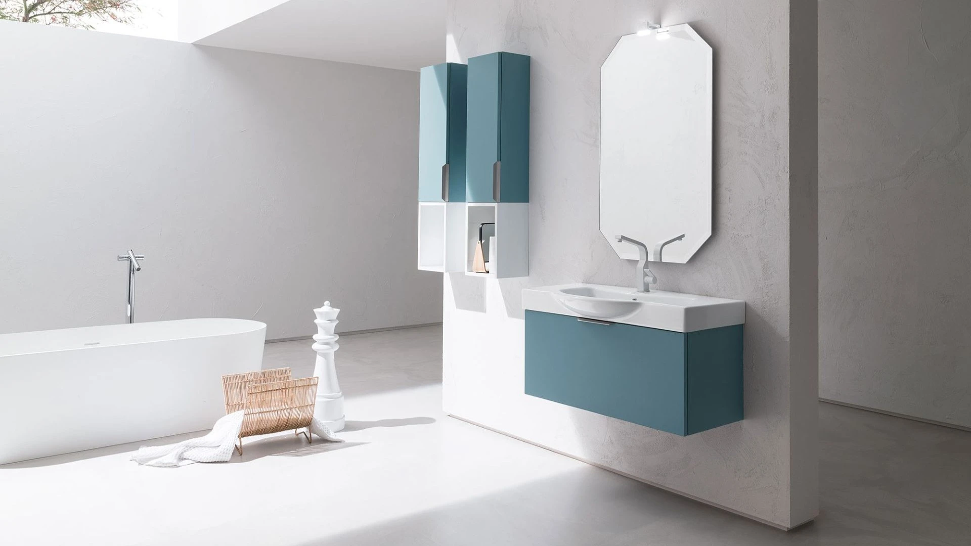 Mobile bagno sospeso Nicolas di BEHOME color ottanio con specchio ottagonale in bagno moderno.