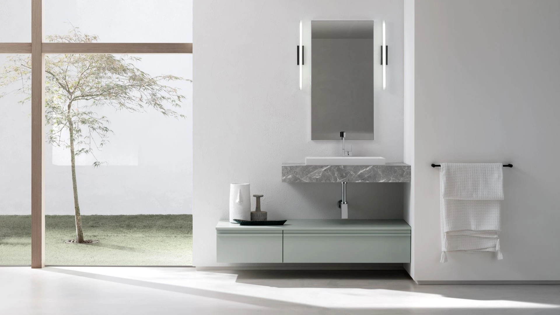 Mobile bagno sospeso Roman di BEHOME verde salvia con top effetto marmo grigio.