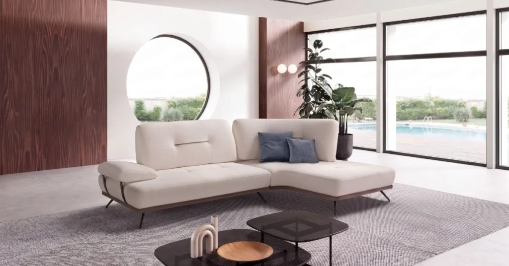 Divano con penisola BEHOME in tessuto bianco all'interno di una moderna veranda a vetri.
